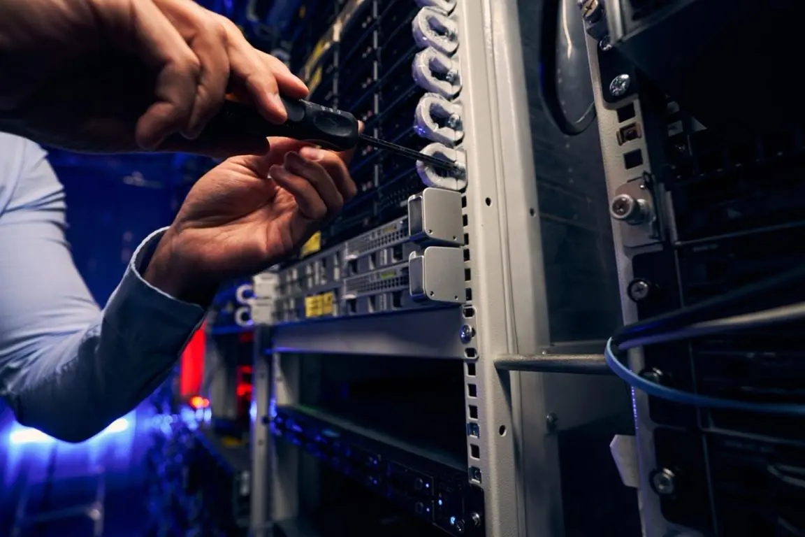 Hands with a screwdriver making edits to a server blade.